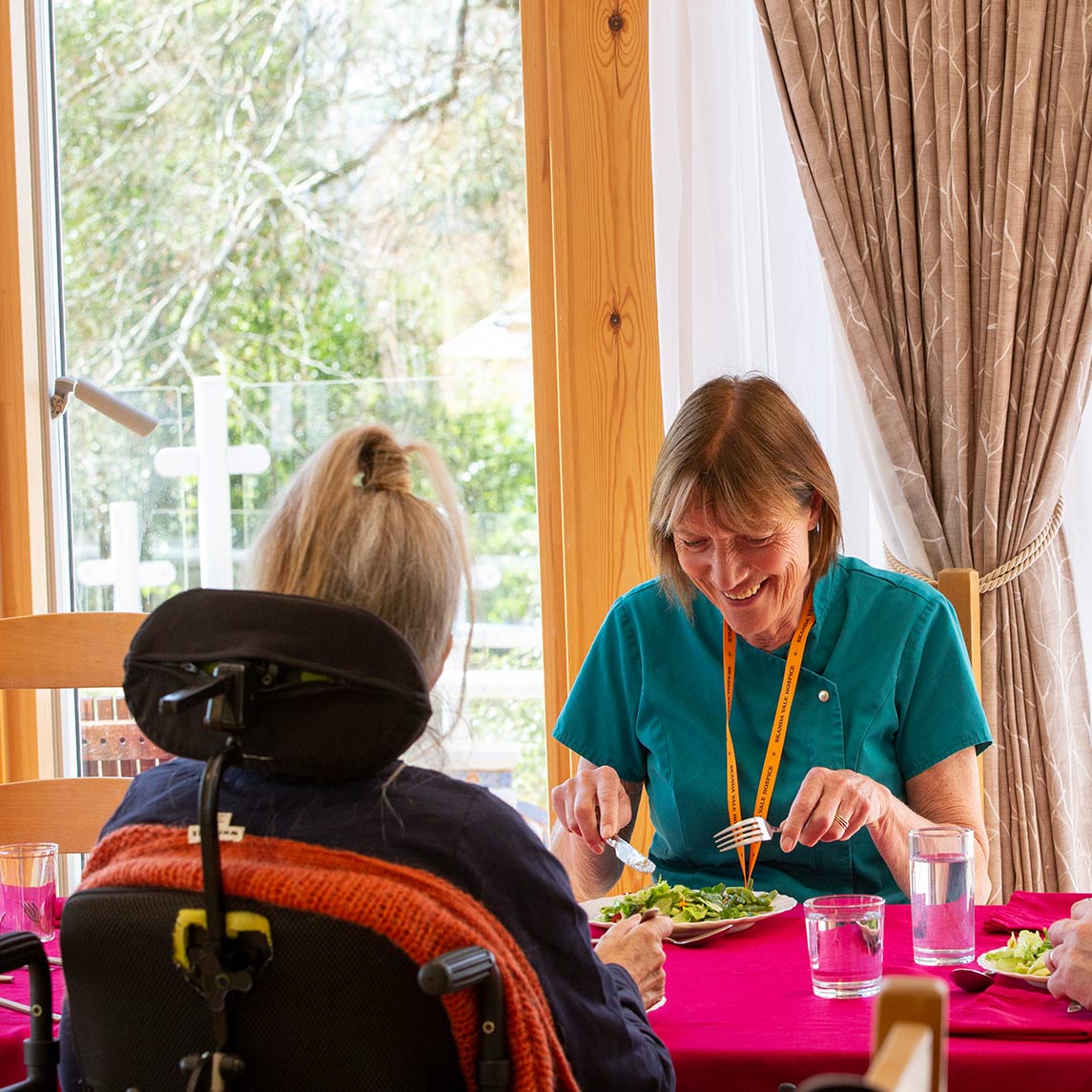 Photo of nurse eating food with residents